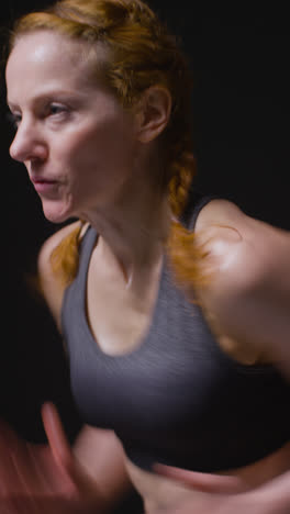 Vertical-Video-Studio-Shot-Of-Mature-Women-Wearing-Gym-Fitness-Clothing-Doing-Cardio-Exercise-Running-On-The-Spot